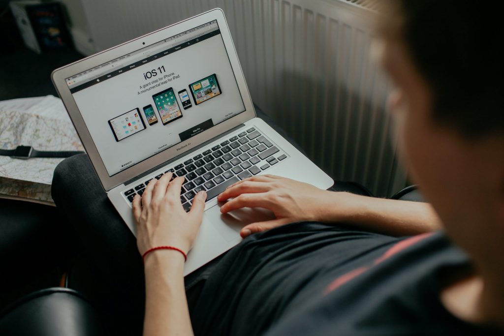 the image shows someone using a laptop computer next to a large white radiator.